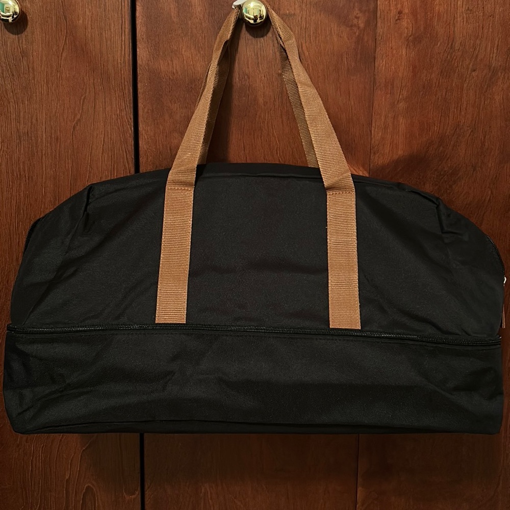 Black weekender bag with brown handles